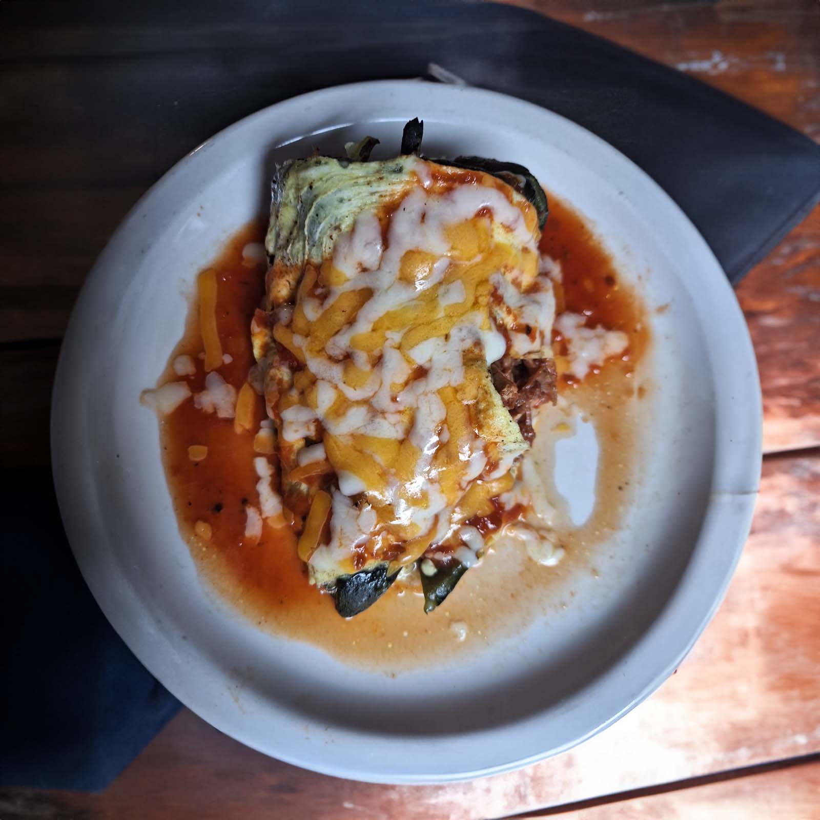 A colorful plate with a variety of Mexican dishes including an enchilada, taco, tamale, and chile relleno, served with rice and beans